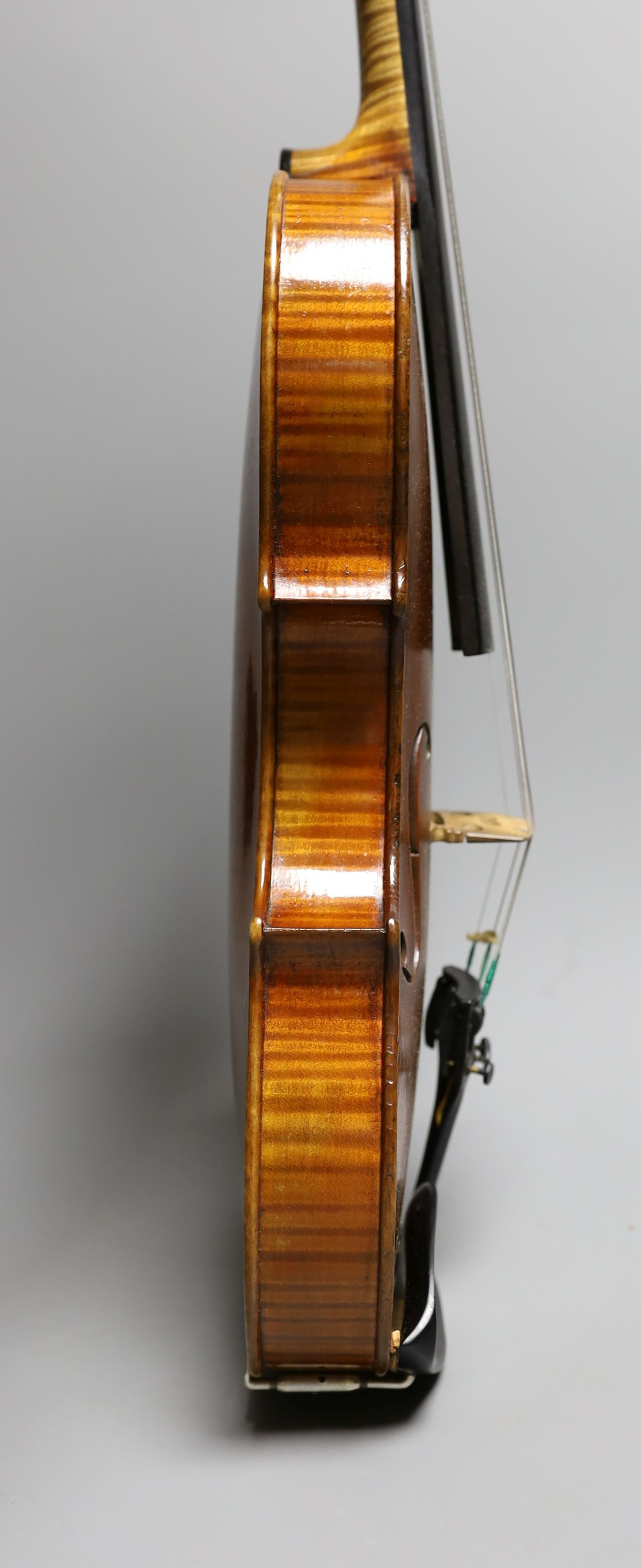 A 19th century violin labelled JB Guadagnini, back measures 35cm, with two bows, one silver-mounted.